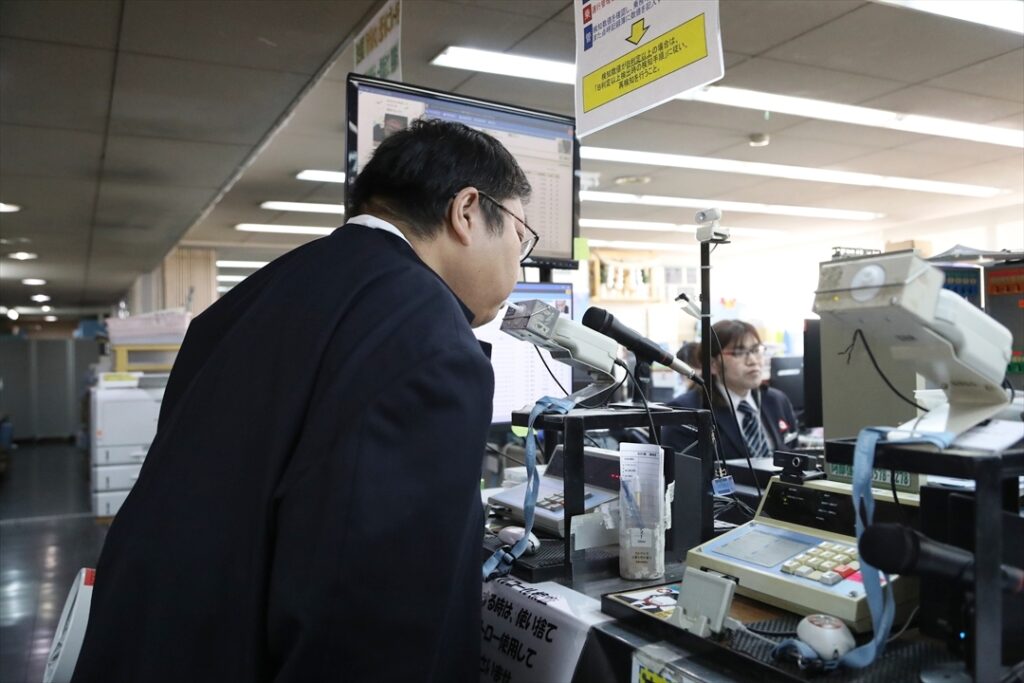 点呼前にアルコールチェックを受ける記者