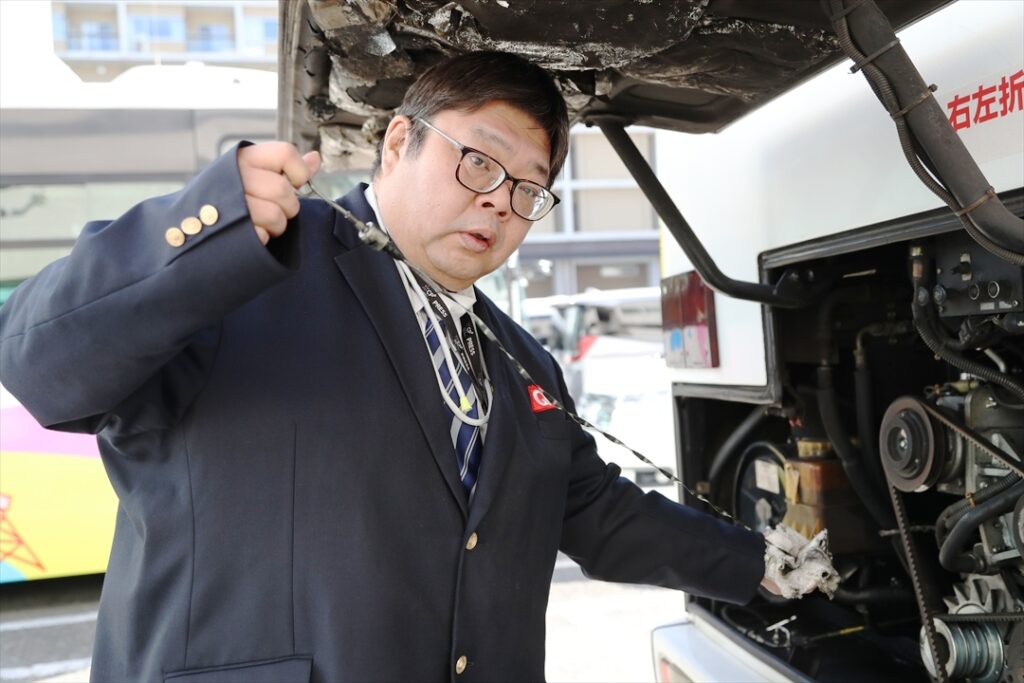 オイル量を点検する記者