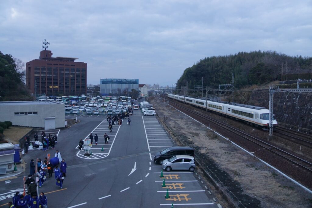 関係者の車やバスの脇を近鉄特急アーバンライナーが駆け抜ける