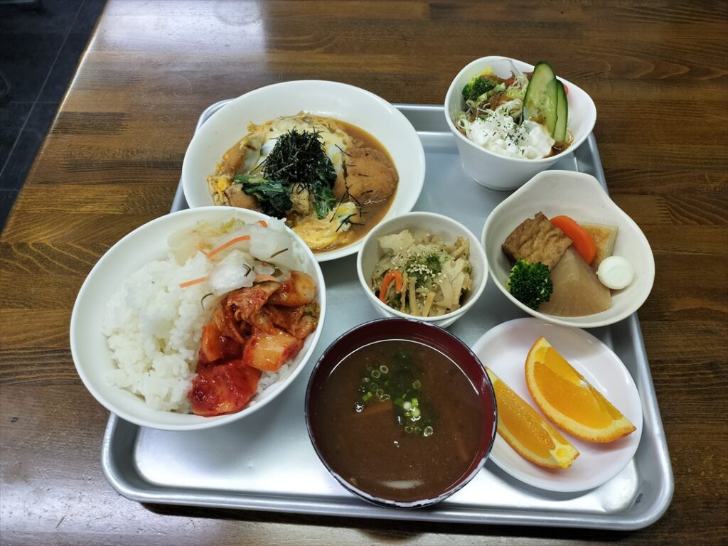 メインに複数の副菜にサラダと汁物とフルーツで標準だがご飯と漬物類は任意で食べ放題