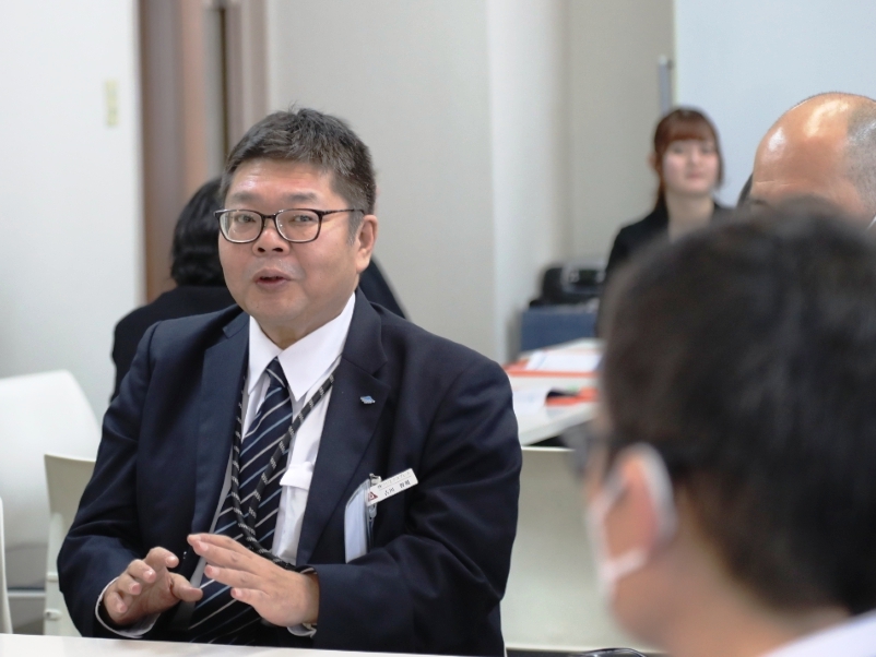 参加者の質問に回答する記者