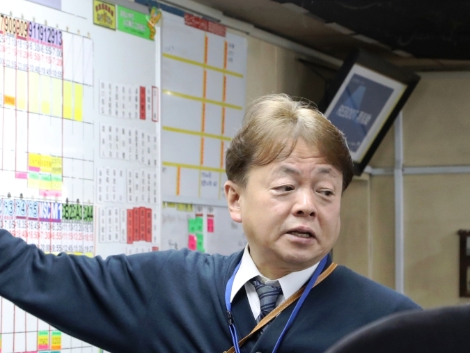 東京営業所の見学会で交番表の説明する藤森常務取締役