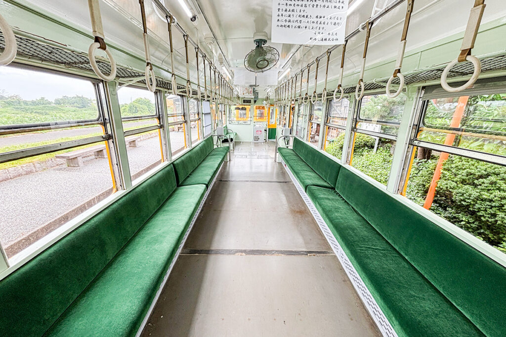 保存車モハ10形11号の車内。グリーンのモケットが張られたロングシートが並ぶ