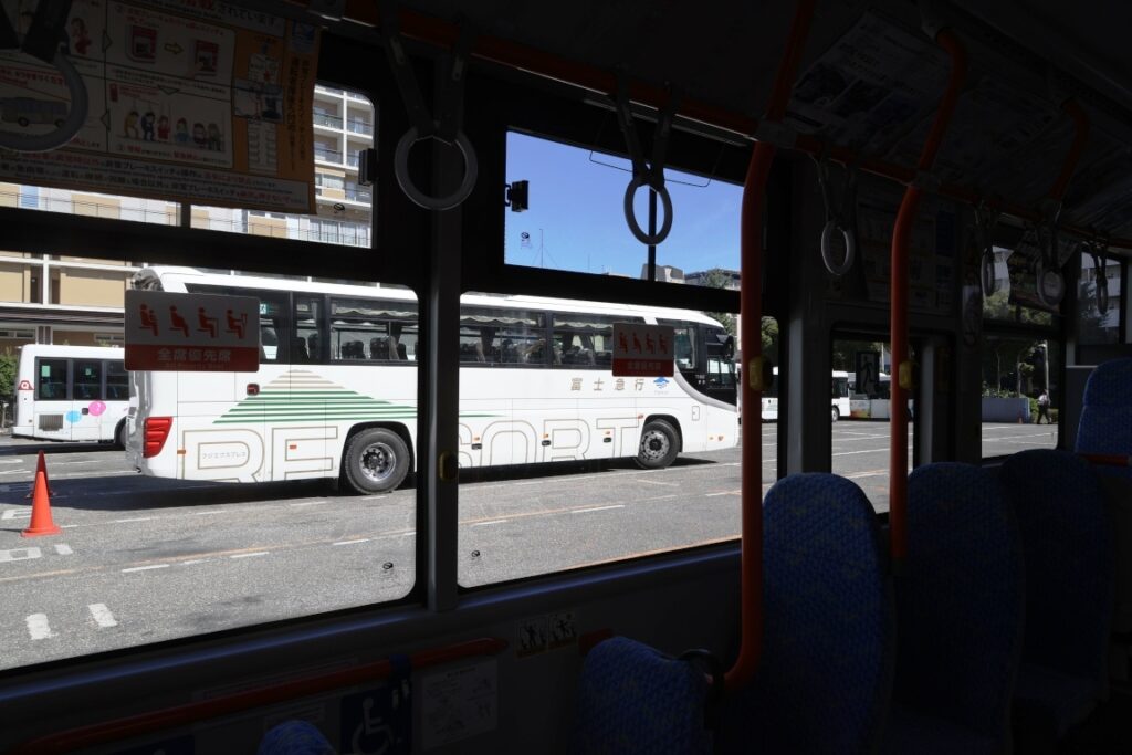 暑いので移動待ちで冷房が効いた電気バス車内から大型車の運転体験の模様を撮影