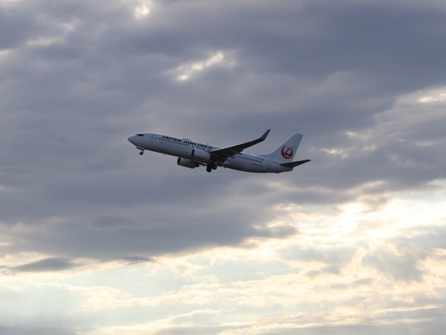 格納庫の前を離陸していくJAL機