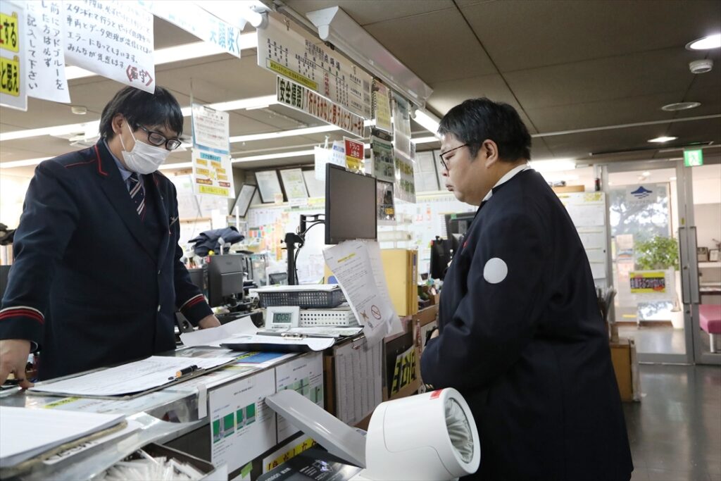 運行管理者から出発点呼を受ける記者