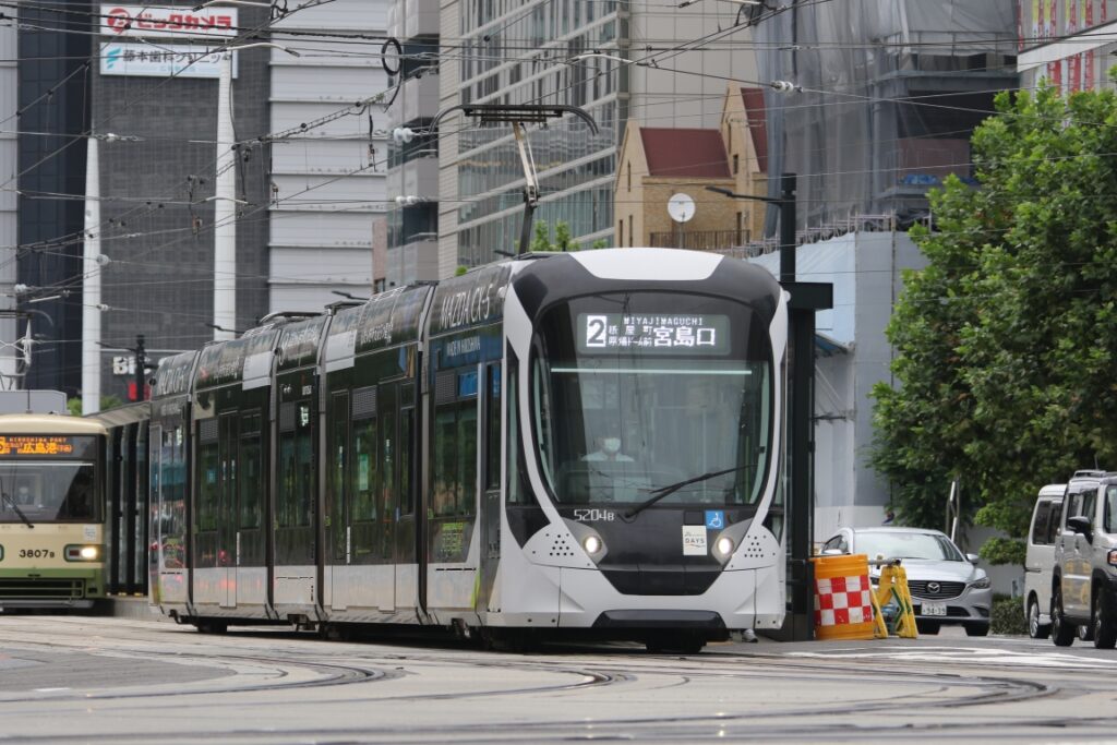 路面から専用軌道を通しで走る宮島口行きの電車