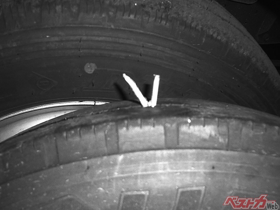 タイヤを横から見たところ。上から差し込まれたゴム紐でパンクの穴を塞ぎます。器具によって先端が穴に差し込まれ、ゴム紐の端がだけが見えています