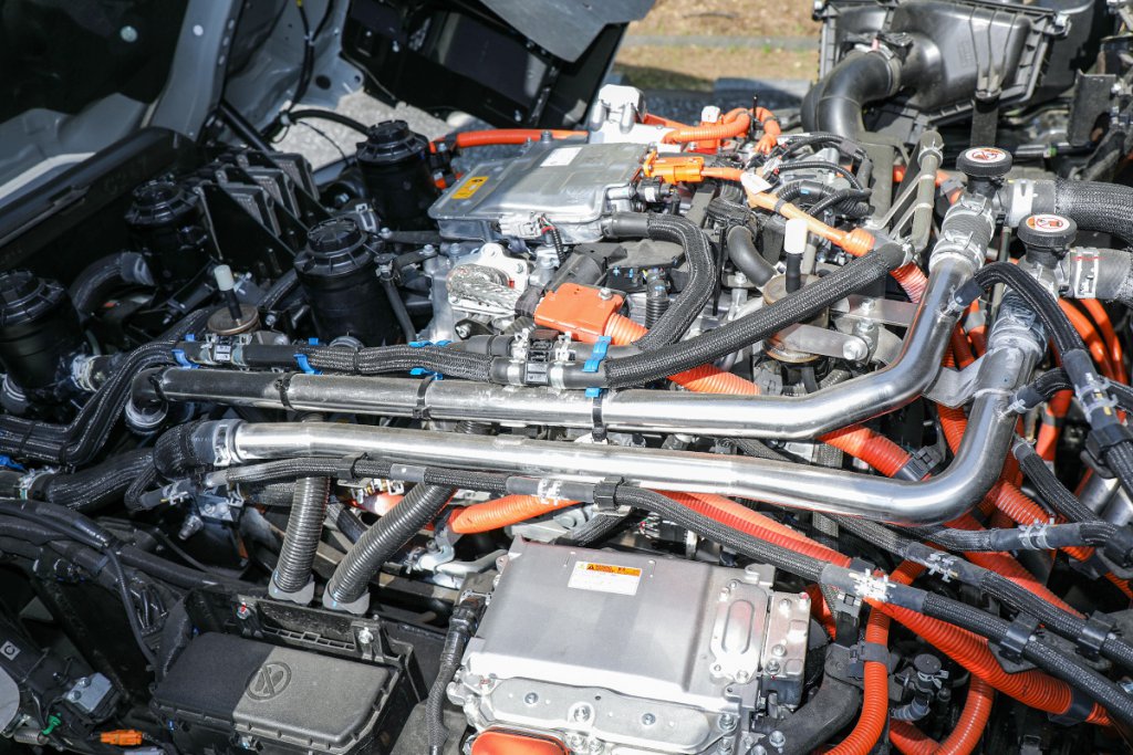 プロフィア大型FCトラックをキャブチルト。エンジンルームにはトヨタ・MIRAIのFCスタックを上下に2基重ねたFCモジュールが収まっている。なお「FCスタック」は、燃料電池セルを集積したユニットで、「FCモジュール」はスタックに給気系・燃料供給系・冷却系などの補機類を備え、発電システムとして完成させたものである