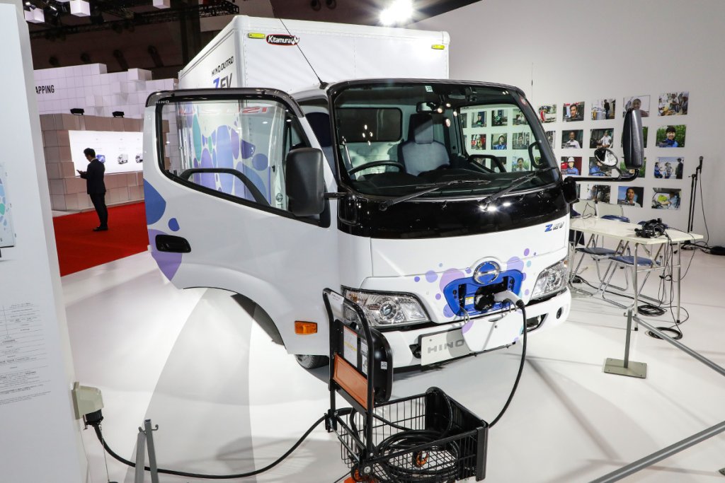 日野・デュトロZ EVアルミバン完成車仕様。手前の台車は、CUBE-LINX社の取り扱い商品の一つ、可搬式普通充電器（出力６kW）