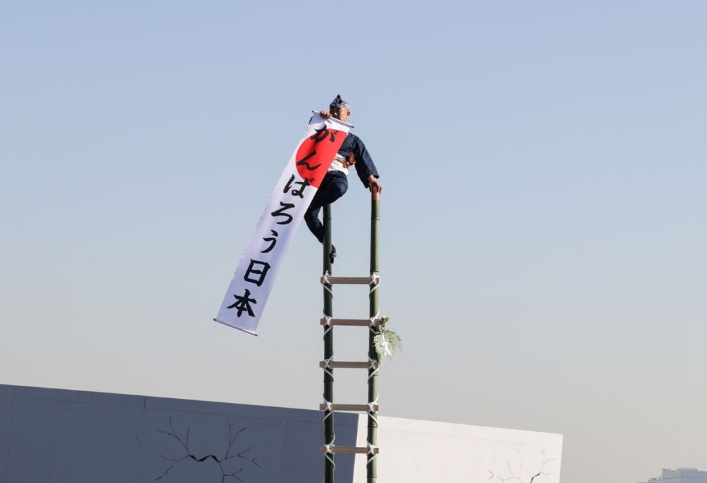 江戸消防記念会による伝統のはしご乗り演技。能登地震を踏まえ「がんばろう日本」などが掲げられた