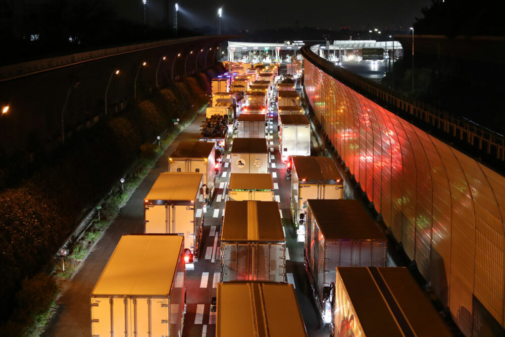 深夜0時の東名高速道路の東京インター。輸送コストを抑えようと時間待ちをしていたトラックが一斉に料金所を通過するため渋滞が発生