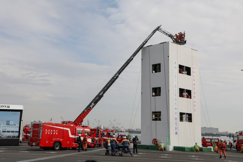 高層ビルの救助現場を想定した消防演技。はしご車や消防ヘリ、ロープ登はんによる救助が披露された