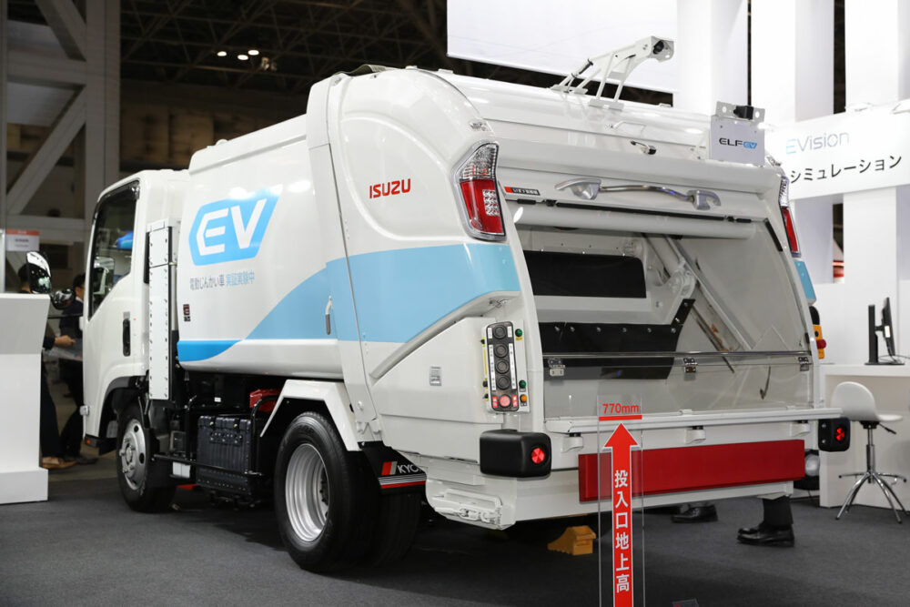 エルフEV塵芥車のリアビュー。ボディは極東開発工業のプレス式・排出板押出式「プレスパック」のエルフEV専用モデル。回転板式も用意する。また、新明和工業、モリタエコノスのプレス式／回転板式も選択可能だ