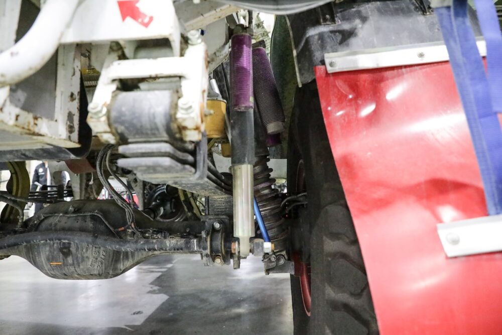 参戦車両のサスペンションは車輪あたりリーフスプリング＋コイルスプリング2本の構成。手前のダンパーは、サスペンションが吸収しきれない入力が起きたとき車体が沈みきらないようにするためのもの