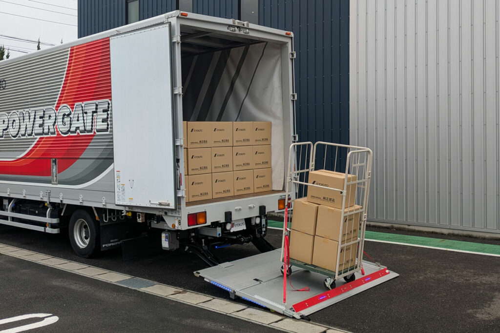 おっと危ないを防止！　荷役時に荷物を固定し安全作業に寄与する極東開発のテールゲートリフト用オプション