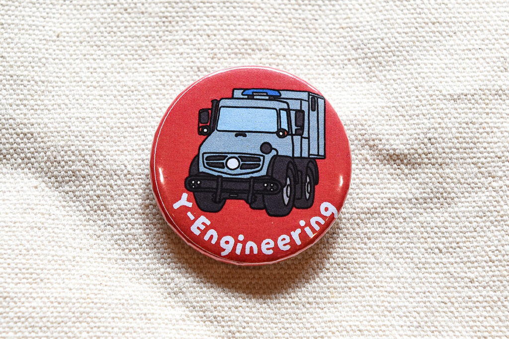 ウニモグのインポーターでもある同社ブースで、ウニモグU5000の缶バッジをゲット！ 可愛くて素敵。ちなみに背景色が異なるバッジもあります