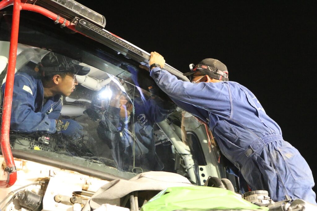 車両の修復に当たる日野チームスガワラ。ガラスを固定する菊池拓実、良川幸司、近内舜