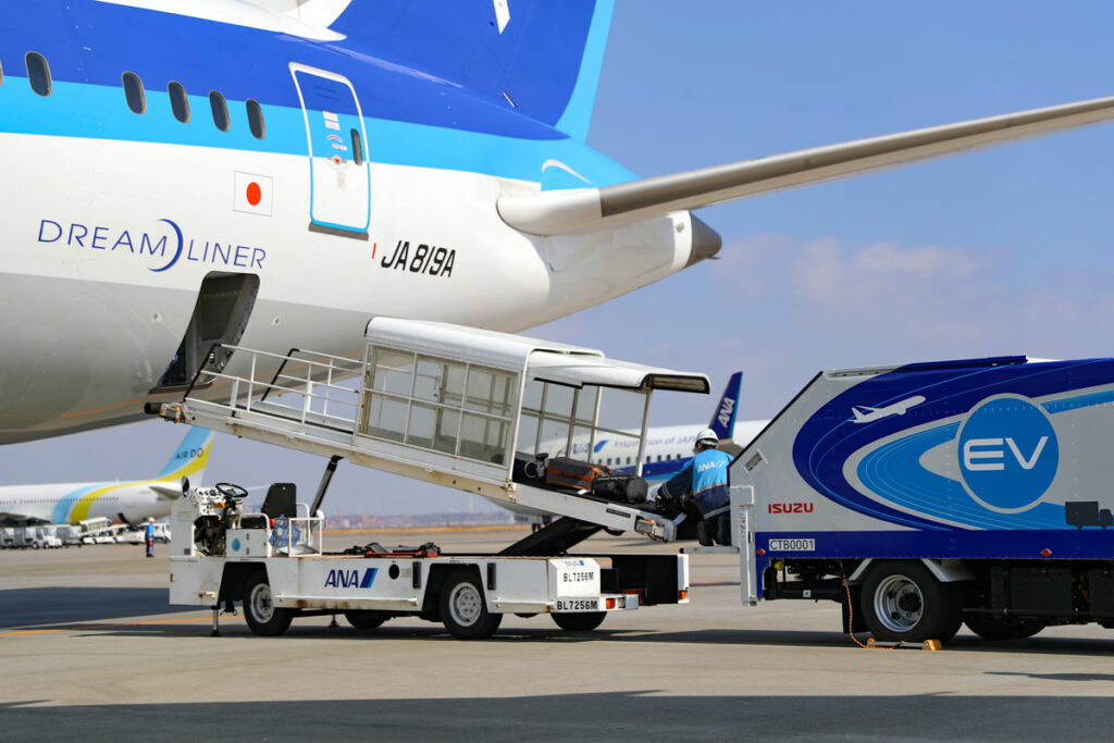 ベルトローダと連携し、運んできた手荷物を機体に積み込む様子