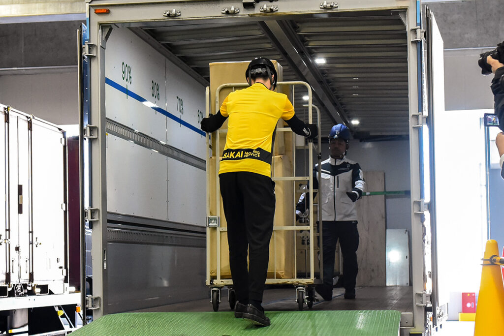 東京レールゲートWEST内のサカイ引越センター拠点でT2の自動運転トラックに積み込み作業を行なうサカイとT2のスタッフ