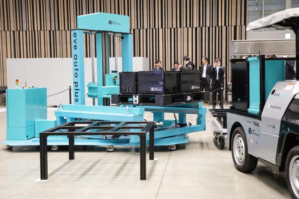 イブオートローダーのデモンストレーション。FG-01が運んできたパレットを架台に移し替えるところ。なお、イブオートローダーは2026年内の発売を予定する