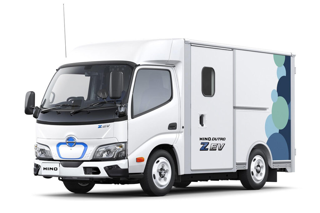 2026年型の日野デュトロZ EV ウォークスルーバン仕様。外観はデザインを改めたフロントバンパーのほか、画像センサー(カメラ)のハウジング形状と搭載位置も変わっている