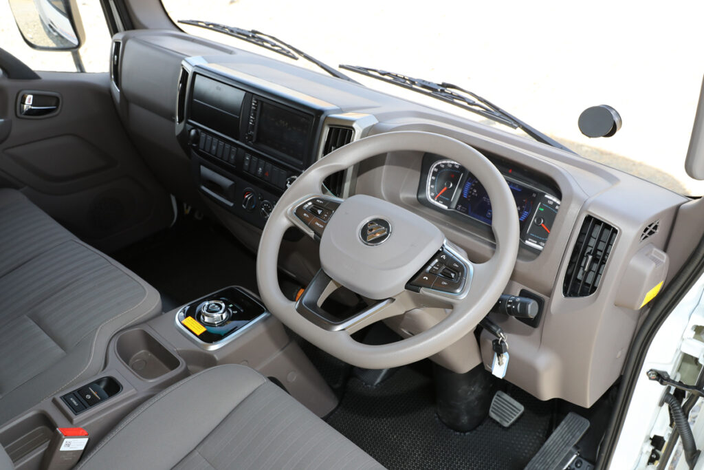 国産ワイドキャブと同等サイズの運転席。右側レバーにウインカー、左側にワイパーを配すレイアウトのため国産車からの乗り換えでも違和感はない
