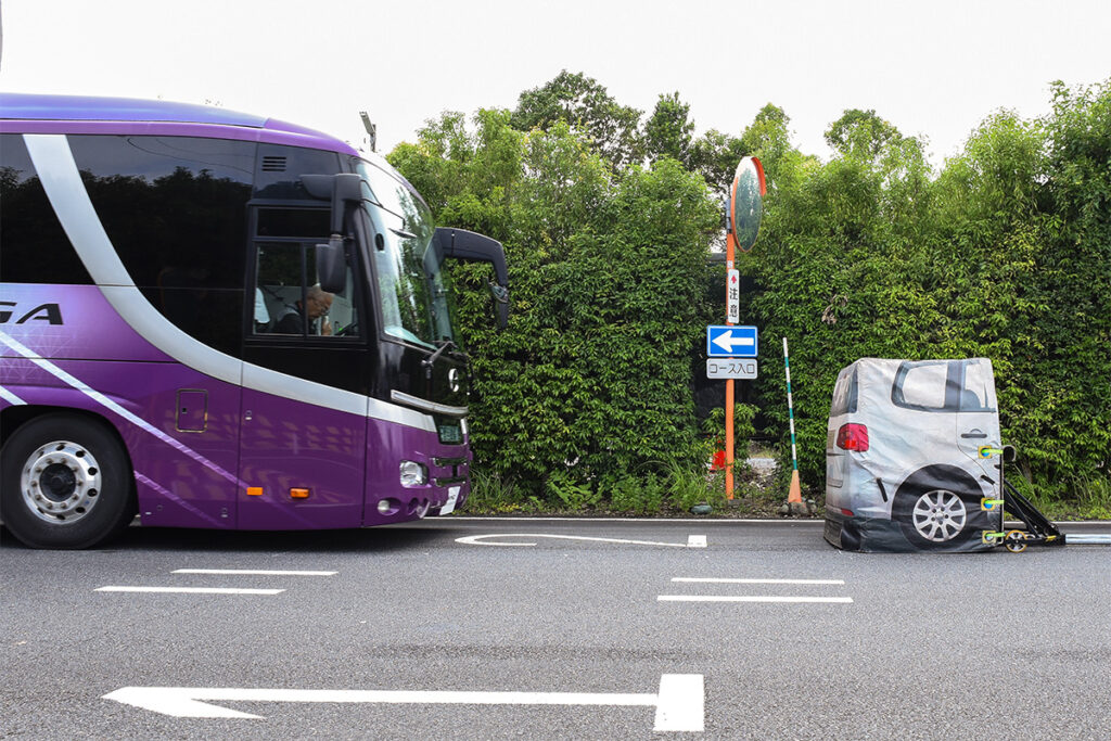 50km/hで走行してきた旧型セレガが、前方に停車中のEVTへの追突を防ぐべく緊急自動ブレーキで急制動を掛けている瞬間。激しくノーズダイブし、ドライバーも大きく前かがみになっている