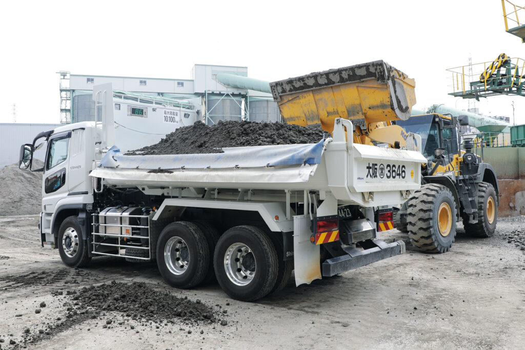 チョウビ工業伏見工場での積み込みデモンストレーションの様子。荷台を約5cm持ち上げる「計量姿勢」をとると、鳥居上部の外部表示機に積載量がリアルタイムに表示される